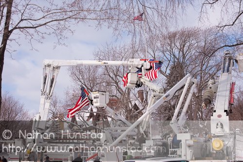 Several flags hang from cherry pickers
